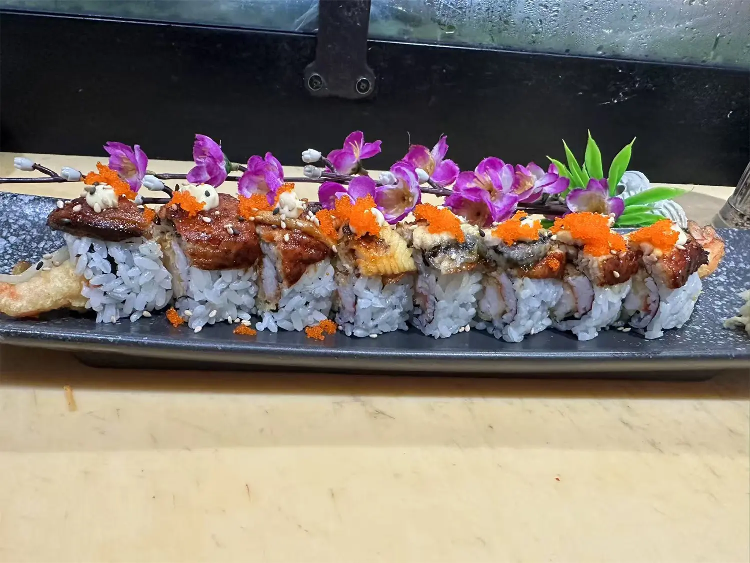Sushi roll topped with crispy tempura bits, spicy mayo, and avocado, offering a crunchy and zesty flavor at Hibachi Express & Sushi, a Japanese restaurant in Oklahoma City