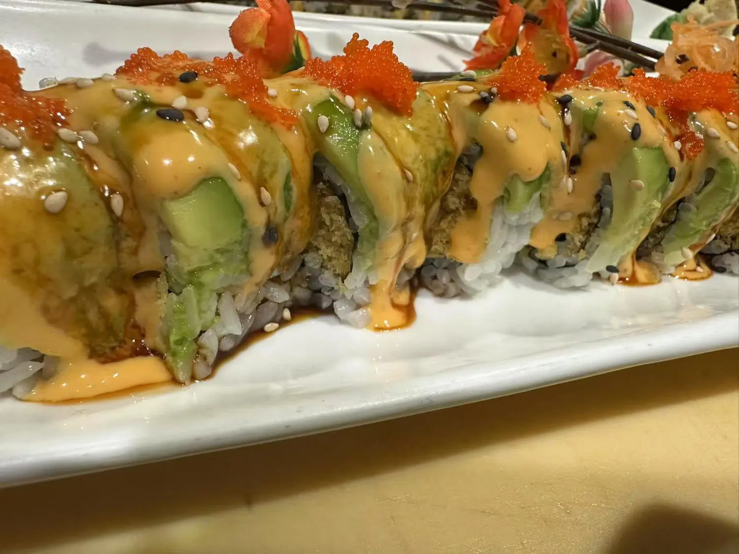 caterpillar Roll topped with crispy tempura bits, spicy mayo, and avocado, offering a crunchy and zesty flavor at Hibachi Express & Sushi, a Japanese restaurant in Oklahoma City